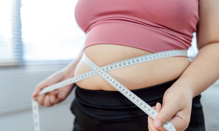 A person measuring her waist

AI-generated content may be incorrect.