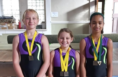 Drie gimnaste ryg medaljes in