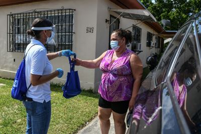 In pandemic-stricken Miami, health workers deliver masks in person