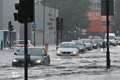 London roads flood as storms roll in