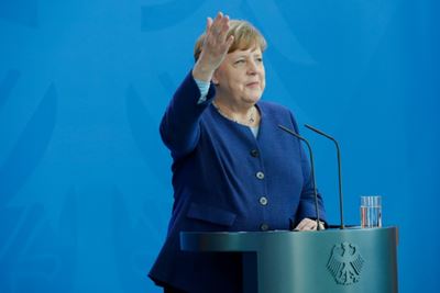 At home, Merkel wins backing for EU aid U-turn
