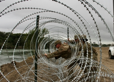 US Army unfurls miles of fencing along border with Mexico
