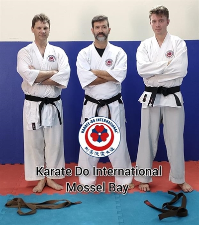Two students receive black belts