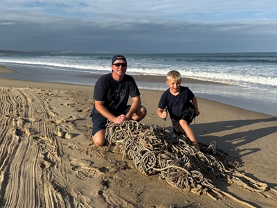 Father, son remove net from beach