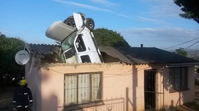 Car plunges through house roof