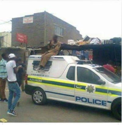 Man sitting on top of police vehicle goes viral on social media